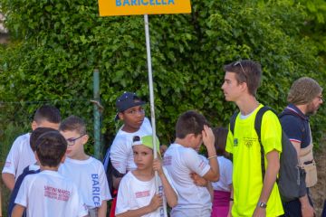 Il cartello con il nome del paese viene portato dai ragazzi durante la cerimonia di apertura